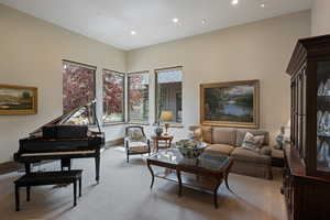 Carpeted living area with recessed lighting and baseboards