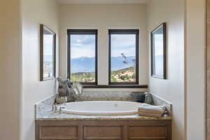 Full bathroom with a mountain view, a garden tub, and healthy amount of natural light