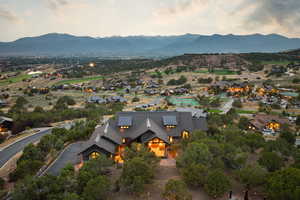 Aerial view of property and surrounding area with a mountain backdrop and nearby suburban area