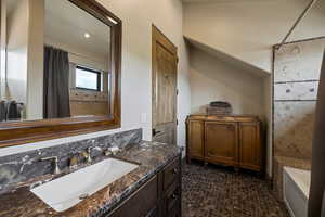 Bathroom with vanity and dark tile patterned floors