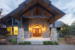 Entrance to property featuring stone siding and covered porch