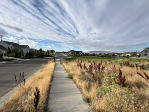 View of asphalt road featuring sidewalks, a residential view, and curbs