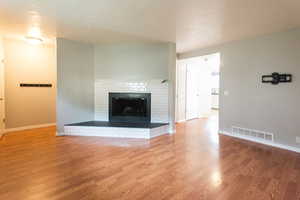 Unfurnished living room with a fireplace and wood finished floors