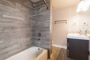 Full bathroom featuring bathtub / shower combination, vanity, and wood finished floors