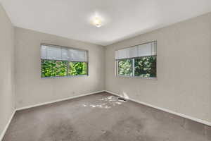 Carpeted spare room with wallpapered walls and baseboards