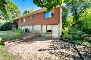 Back of house with a patio area and brick siding