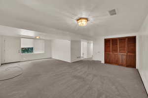 Unfurnished living room with a textured ceiling and carpet flooring