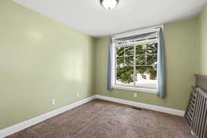 Empty room featuring carpet floors and baseboards