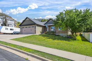 Craftsman-style home featuring driveway, a garage, and stone siding