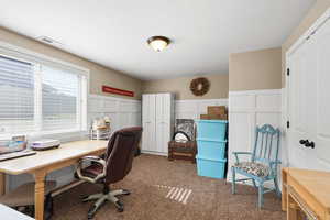 Carpeted office with a decorative wall and a wainscoted wall