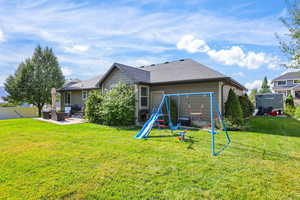 Rear view of property featuring a patio area, a playground, roof with shingles, and an outdoor living space