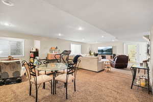 Carpeted dining room featuring a textured ceiling and recessed lighting