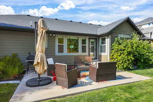 Rear view of house featuring a patio area and roof with shingles