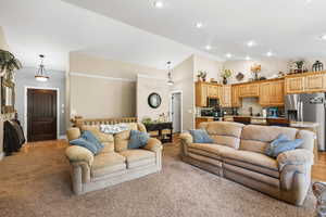 Living room with high vaulted ceiling, light carpet, and recessed lighting