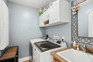 Washroom featuring washing machine and clothes dryer and cabinet space