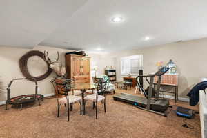 Exercise room featuring carpet flooring, a textured ceiling, and recessed lighting