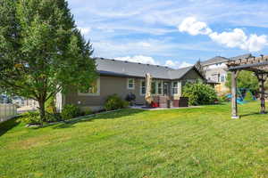 Back of house featuring a patio, a pergola, and a shingled roof