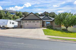 Craftsman-style house with a front yard, driveway, and an attached garage