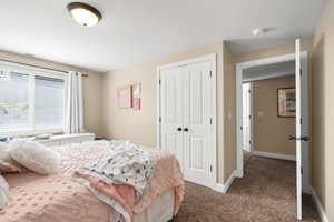 Carpeted bedroom with a closet and a textured ceiling