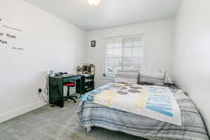 Bedroom featuring carpet and baseboards