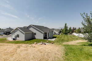 View of side of property with a fire pit, a patio area, and yard.