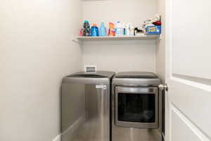 Laundry room featuring tile patterned floors and washing machine and clothes dryer