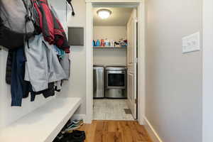 Mudroom featuring light wood-style flooring and separate washer and dryer