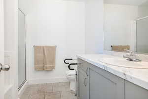 Full bath with vanity, light tile patterned floors, and a stall shower