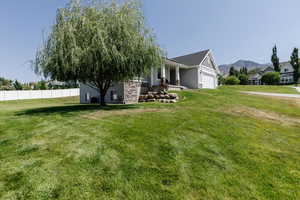 View of front of house with an attached garage, a mountain view, and covered porch