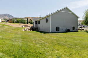 View of side of property featuring a yard and a mountain view