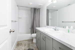 Bathroom with vanity, shower / bath combo with shower curtain, and light tile patterned floors