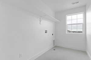 Washroom featuring washer hookup, electric dryer hookup, and light tile patterned floors