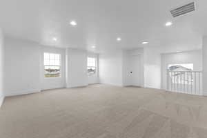 Empty room featuring recessed lighting and light colored carpet
