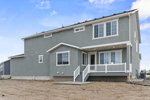 Back of property with stucco siding and a wooden deck