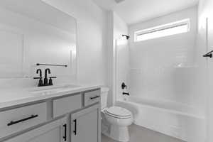 Bathroom featuring shower / tub combination, light tile patterned floors, and vanity