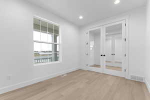 Spare room with french doors, recessed lighting, and light wood finished floors
