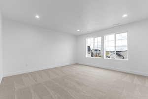 Empty room featuring light carpet and recessed lighting