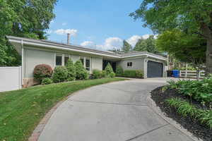 Ranch-style home featuring a garage, driveway, and brick siding