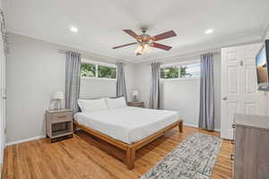 Bedroom with ornamental molding, multiple windows, light wood-type flooring, ceiling fan, and recessed lighting