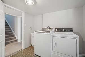 Washroom featuring cabinet space and washer and dryer