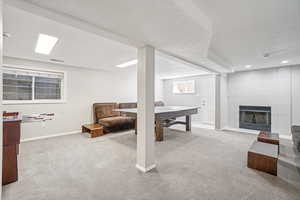 Rec room with carpet flooring, a textured ceiling, recessed lighting, and a tile fireplace