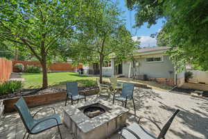 Fenced backyard with an outdoor fire pit and a patio area