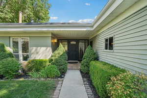 View of exterior entry featuring brick siding