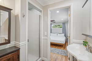 Bathroom featuring a shower stall, crown molding, ensuite bathroom, wood finished floors, and vanity