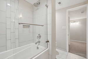 Bathroom featuring bathing tub / shower combination and tile patterned flooring