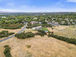 Aerial perspective of suburban area featuring a mountain backdrop and a tree filled landscape