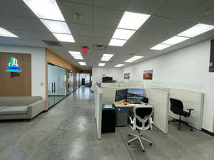 Office area with concrete floors and a paneled ceiling