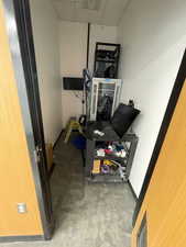 Workout area with a paneled ceiling and baseboards