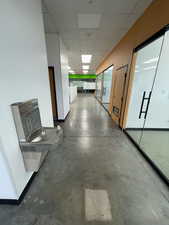 Hall featuring a paneled ceiling and concrete flooring