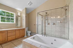 Bathroom featuring a bath, vaulted ceiling, double vanity, light tile patterned floors, and a baseboard radiator